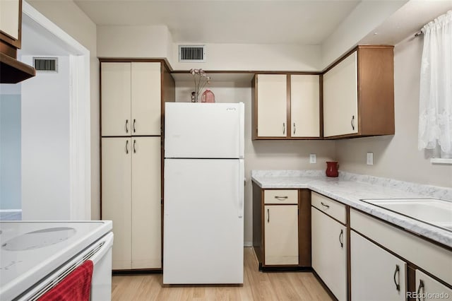 kitchen featuring white refrigerator and light hardwood / wood-style floors