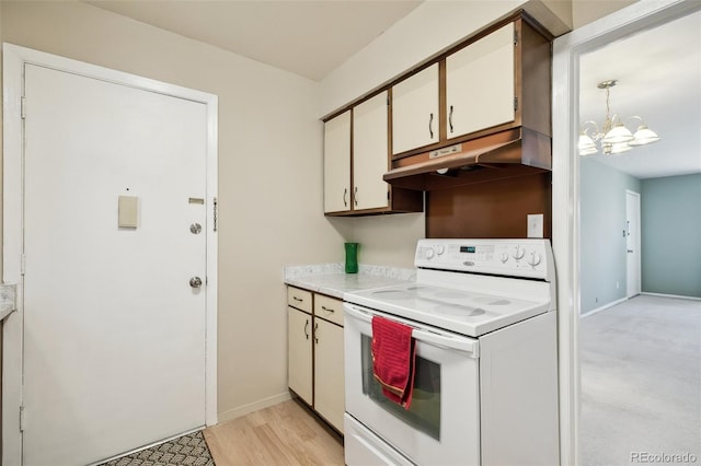 kitchen featuring white cabinets, an inviting chandelier, electric range, and pendant lighting