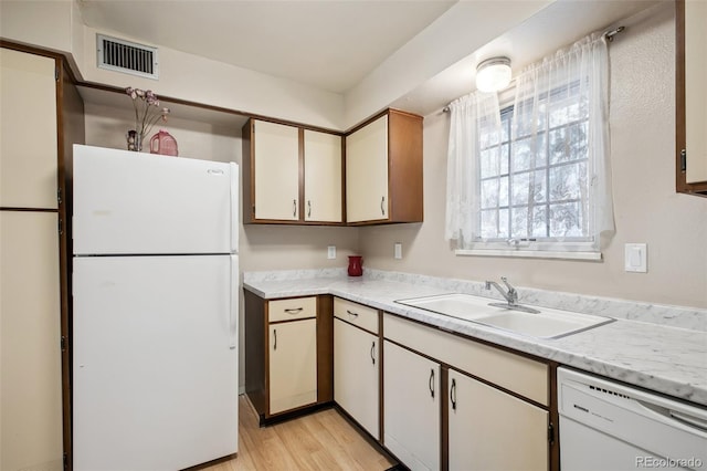 kitchen with sink, white appliances, and light wood-type flooring