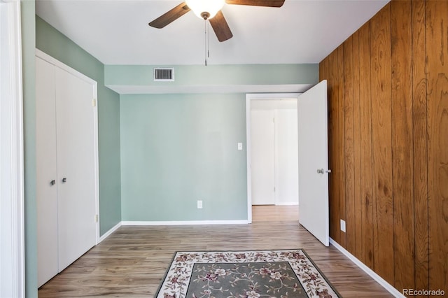 unfurnished bedroom with a closet, ceiling fan, and light wood-type flooring