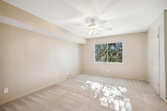 carpeted spare room with ceiling fan