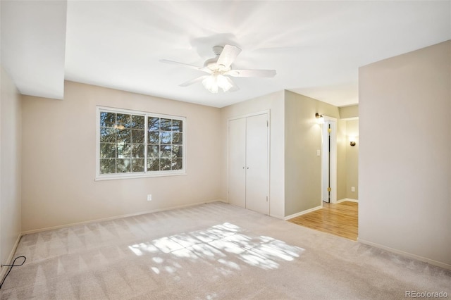 unfurnished bedroom with ceiling fan, light colored carpet, and a closet