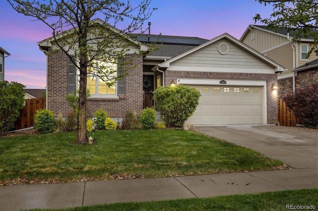 25811 E Archer Ave, Aurora, CO 80018 - view of front of house featuring brick siding, concrete driveway, roof mounted solar panels, and an attached garage