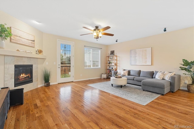25811 E Archer Ave, Aurora, CO 80018 - living room featuring ceiling fan, a tile fireplace, light wood finished floors, and baseboards