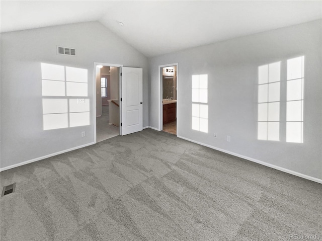 interior space with carpet floors, vaulted ceiling, visible vents, and connected bathroom