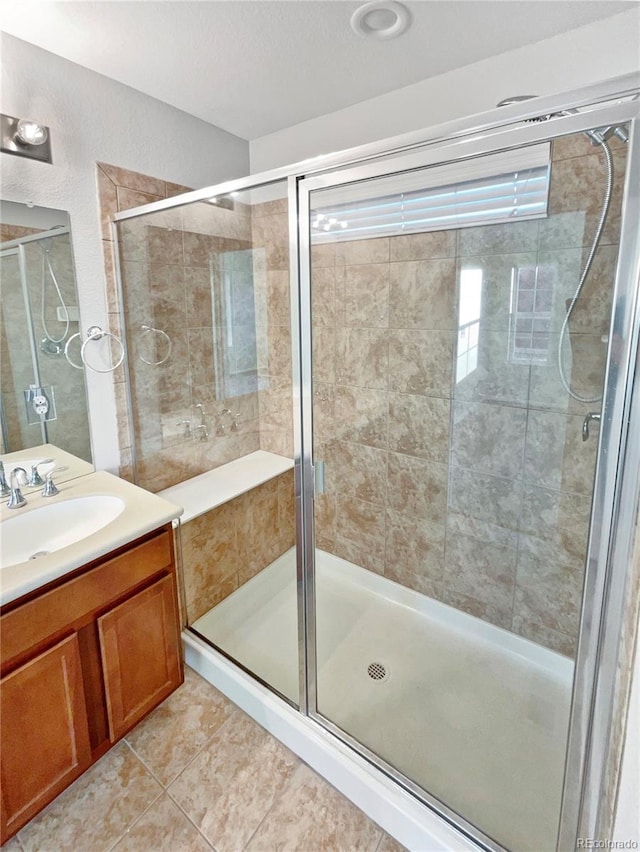 bathroom with a stall shower, tile patterned flooring, and vanity