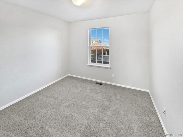 unfurnished room featuring baseboards, visible vents, and carpet flooring