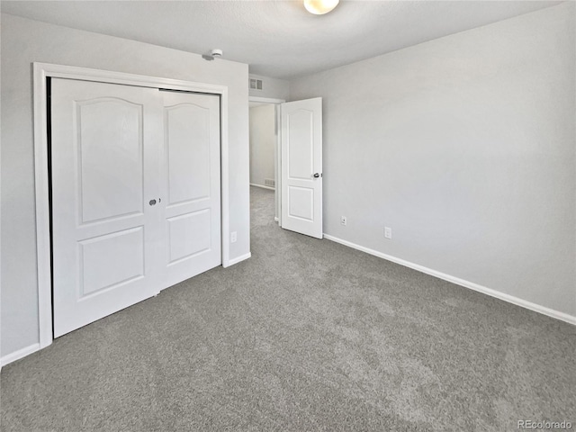 unfurnished bedroom with visible vents, a closet, baseboards, and carpet flooring