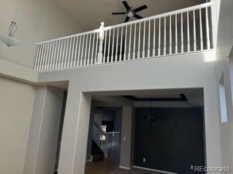 staircase with a high ceiling and ceiling fan