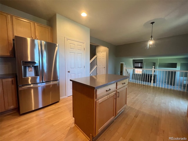 kitchen with a center island, stainless steel refrigerator with ice dispenser, and light wood-type flooring