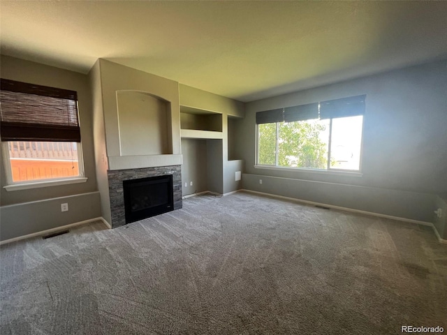 unfurnished living room featuring carpet floors and a fireplace