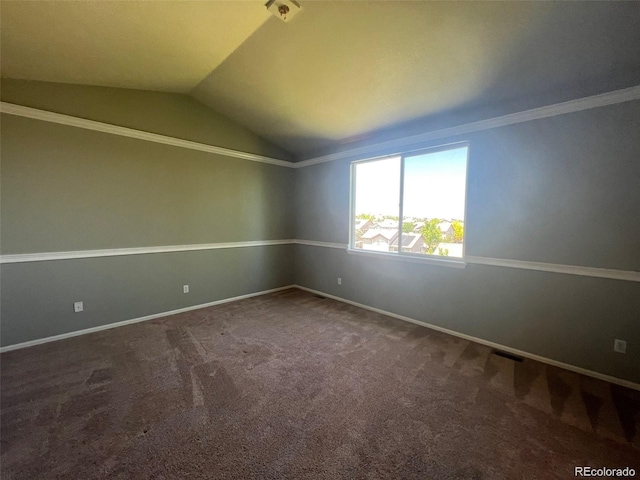 carpeted empty room with vaulted ceiling and crown molding