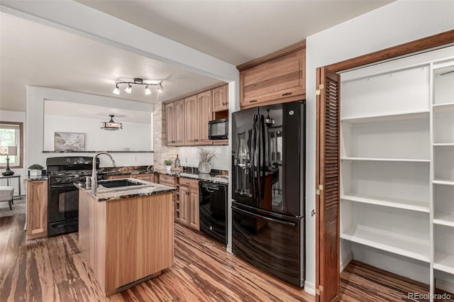 1060 S Eaton St, Lakewood, CO 80226 - kitchen with black appliances, dark stone countertops, wood finished floors, an island with sink, and a peninsula