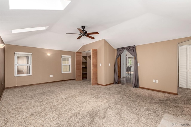 1060 S Eaton St, Lakewood, CO 80226 - unfurnished living room with a skylight, ceiling fan, carpet flooring, vaulted ceiling, and healthy amount of natural light