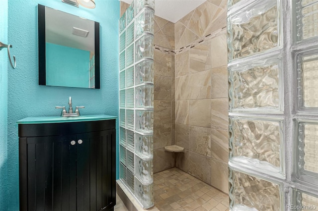 1060 S Eaton St, Lakewood, CO 80226 - full bath with walk in shower, vanity, and a textured wall