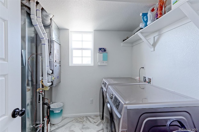 washroom featuring a textured ceiling and washer and clothes dryer