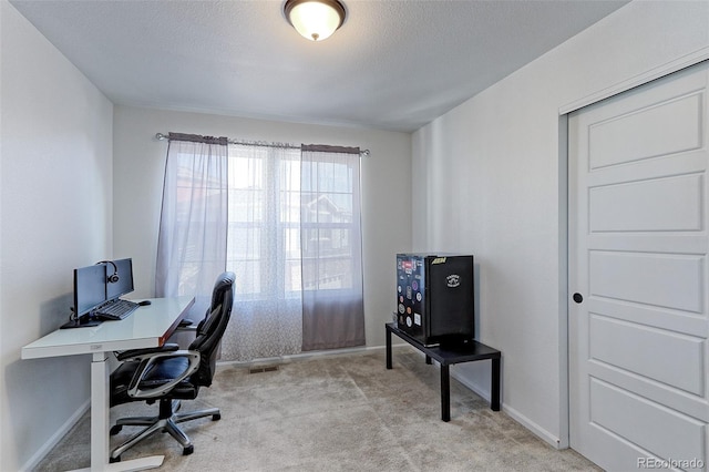 carpeted office with a textured ceiling