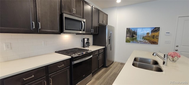 9279 Merino Ct Unit B, Littleton, CO 80125 - kitchen with appliances with stainless steel finishes, light wood-style flooring, light countertops, decorative backsplash, and dark brown cabinets