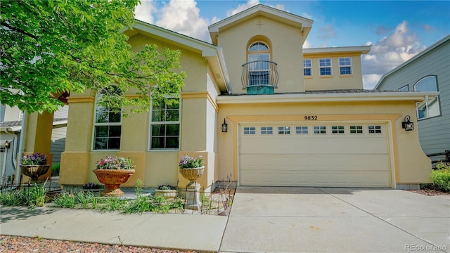 9832 N Crystal Lake Dr, Littleton, CO 80125 - mediterranean / spanish-style house with stucco siding, concrete driveway, a balcony, and a garage