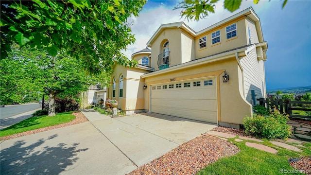 9832 N Crystal Lake Dr, Littleton, CO 80125 - view of front facade featuring a garage, stucco siding, and concrete driveway