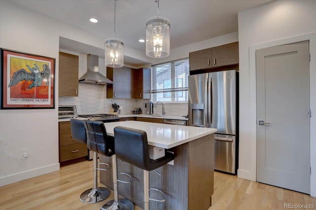 kitchen with stainless steel fridge with ice dispenser, light countertops, wall chimney exhaust hood, modern cabinets, and a center island