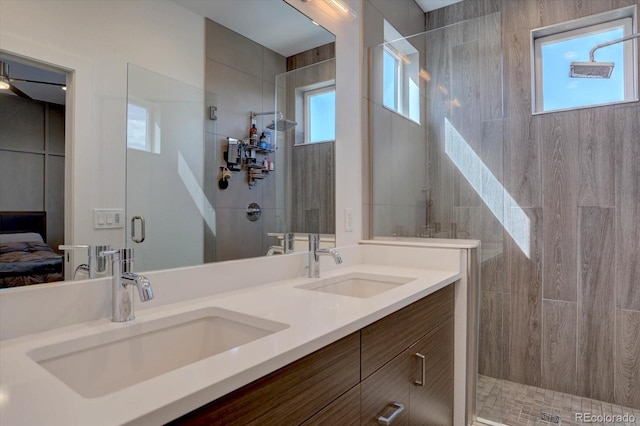 ensuite bathroom with a sink, walk in shower, ensuite bath, and double vanity