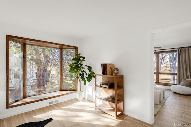 living area featuring visible vents and wood finished floors