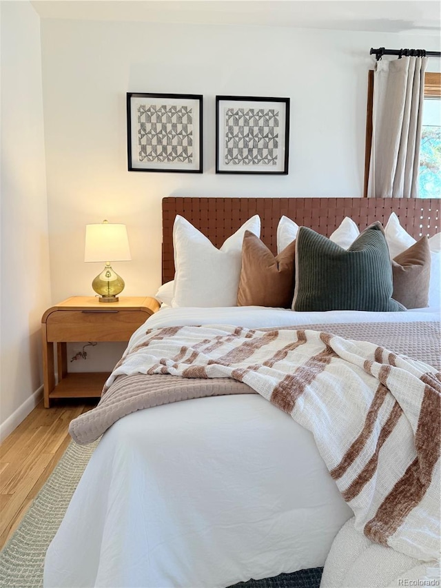 bedroom featuring wood finished floors and baseboards