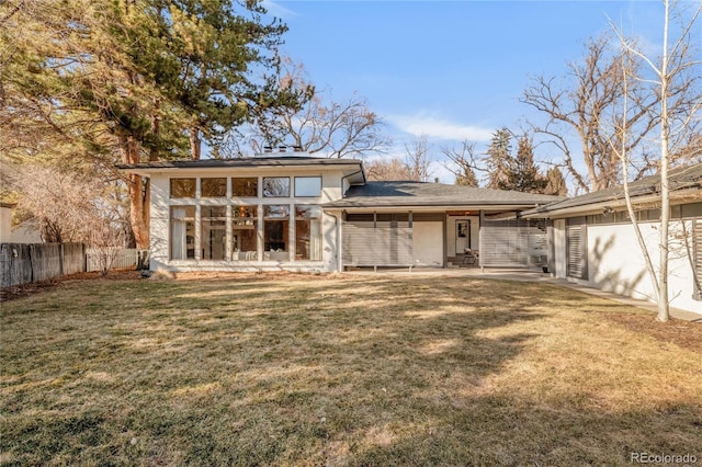 rear view of property with a lawn, a patio, and fence