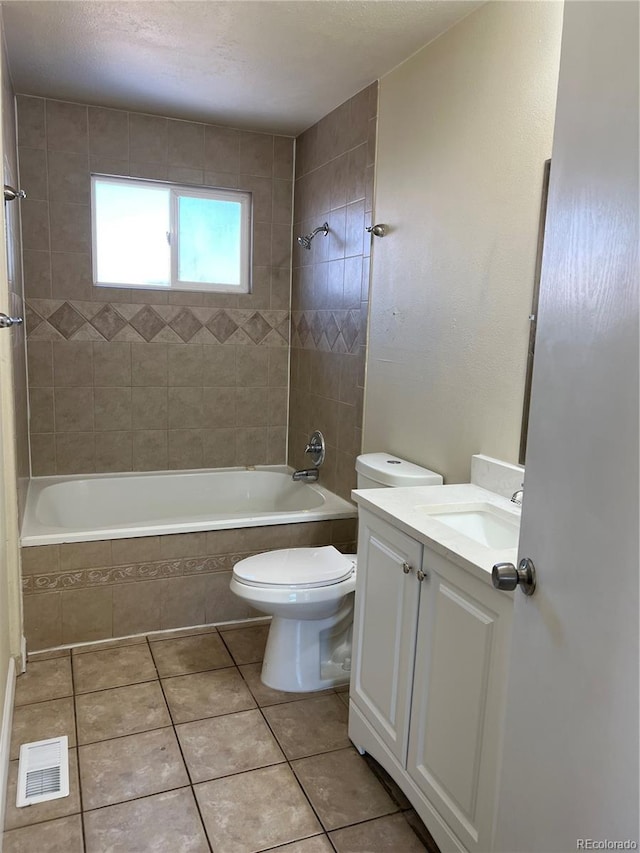 full bathroom featuring tile patterned floors, vanity, toilet, and tiled shower / bath