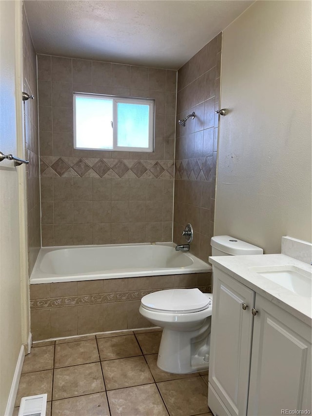 full bathroom featuring vanity, tiled shower / bath, tile patterned flooring, toilet, and a textured ceiling