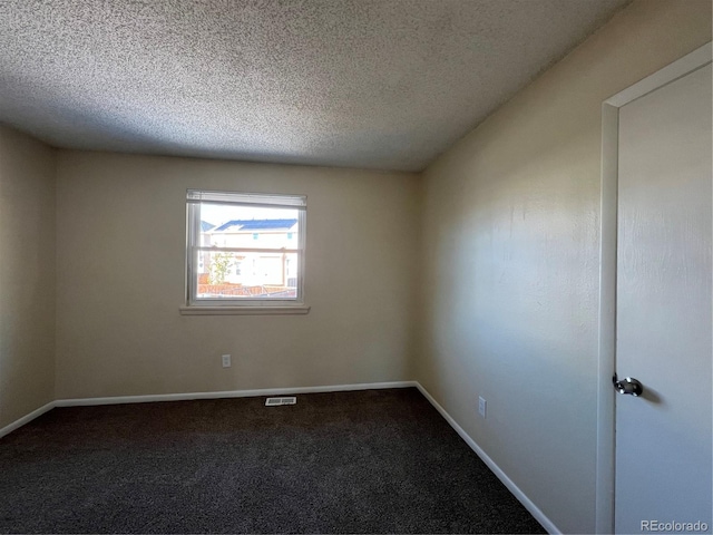 carpeted empty room featuring a textured ceiling