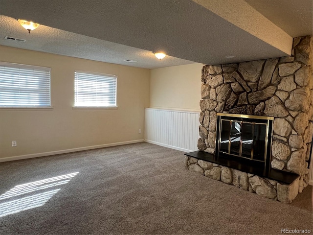 unfurnished living room featuring carpet, a fireplace, and a textured ceiling