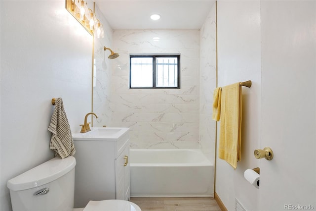 full bathroom with vanity, toilet, wood-type flooring, and tiled shower / bath combo