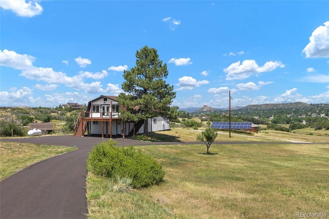 view of front of house with a mountain view and a front lawn