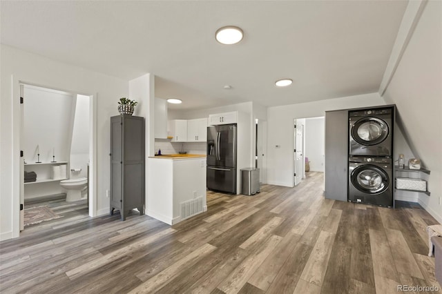 kitchen featuring white cabinets, wood-type flooring, stainless steel fridge with ice dispenser, and wooden counters