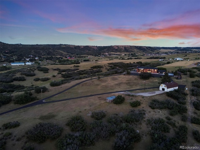 aerial view at dusk featuring a mountain view