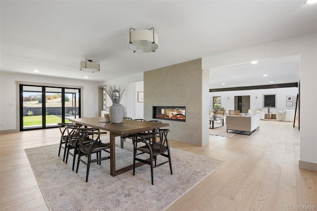 dining room with a large fireplace and light hardwood / wood-style flooring