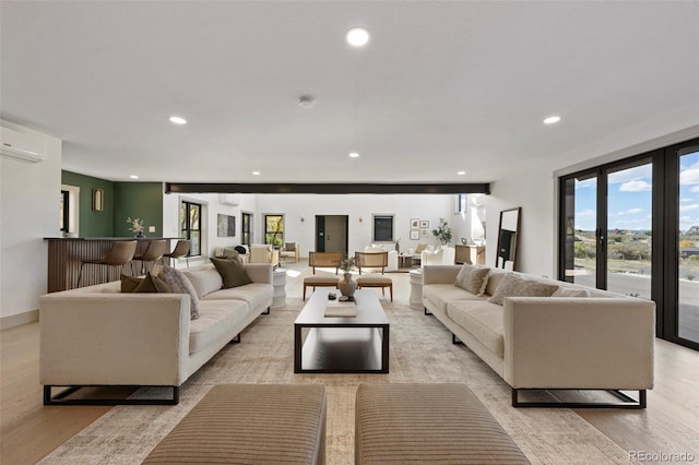 living room featuring light wood-type flooring and a wall unit AC