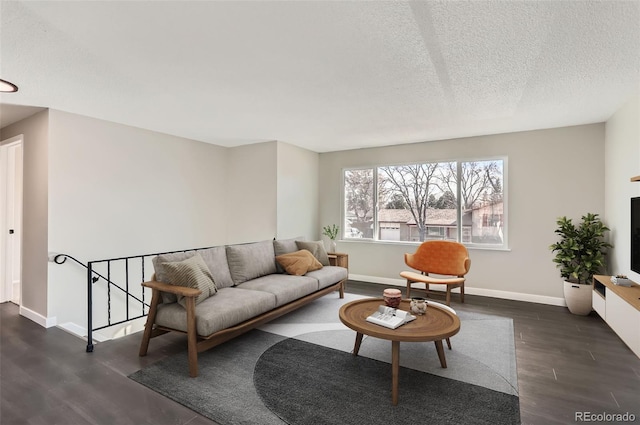 living area featuring dark wood-style floors, baseboards, and a textured ceiling