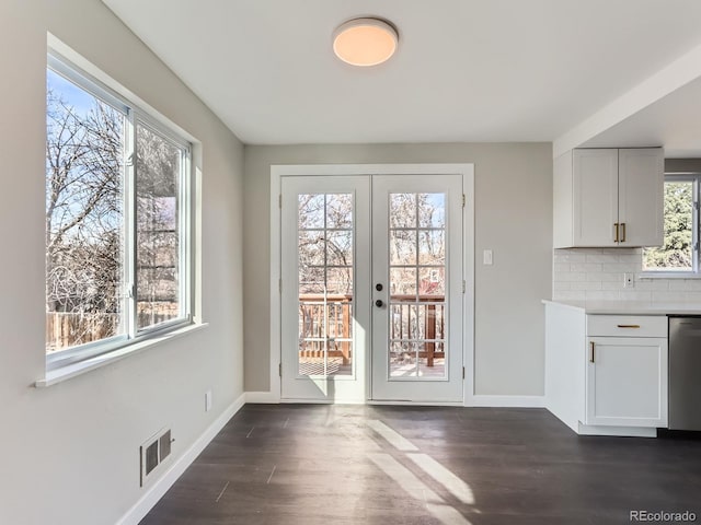 doorway with visible vents, baseboards, and dark wood finished floors