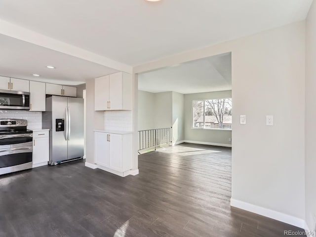 kitchen featuring backsplash, stainless steel appliances, light countertops, and dark wood-style flooring