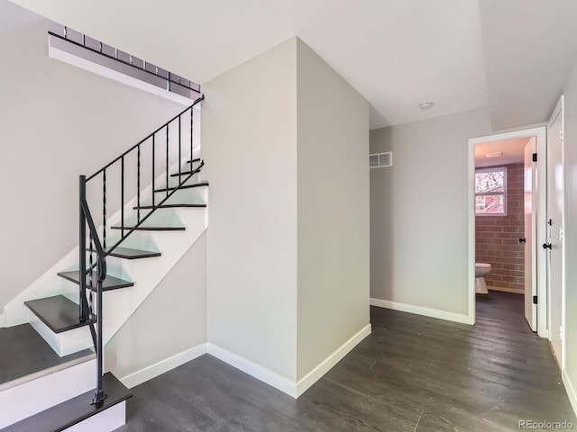 stairs featuring visible vents, baseboards, and wood finished floors