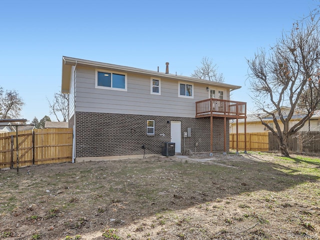 back of house with brick siding, central AC, and a fenced backyard