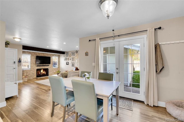 3561 W 131st Ave, Broomfield, CO 80020 - dining space with wood finished floors, a fireplace, french doors, recessed lighting, and baseboards