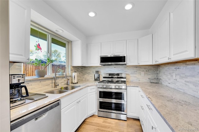 3561 W 131st Ave, Broomfield, CO 80020 - kitchen featuring appliances with stainless steel finishes, a sink, white cabinets, recessed lighting, and decorative backsplash