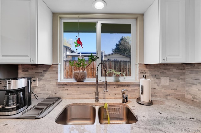 3561 W 131st Ave, Broomfield, CO 80020 - kitchen featuring a sink, tasteful backsplash, white cabinets, and light stone countertops
