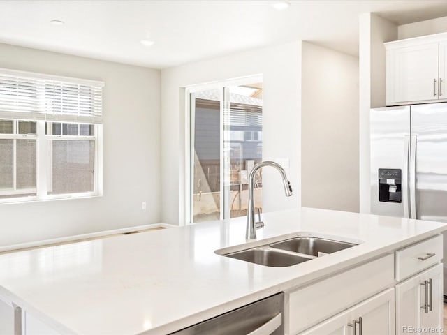 kitchen featuring recessed lighting, a sink, white cabinets, light countertops, and appliances with stainless steel finishes