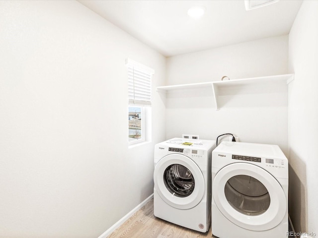 laundry area featuring washing machine and clothes dryer, visible vents, light wood-type flooring, laundry area, and baseboards