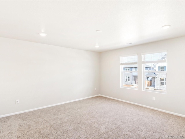 carpeted spare room featuring baseboards